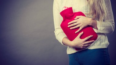 Ağrılı dönemler ve menstrüel kramp sorunları kavramı. Mide krampları sıcak su şişesi tutan çok hasta hissediyorum sahip kadın.