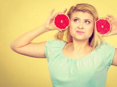 Sağlıklı beslenme, vitamin dolu ferahlatıcı yiyecekler. Mutlu kadın elinde tatlı narenciye, kırmızı greyfurt tutuyor..