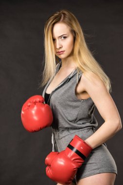 Şehvetli genç kadın, sarışın çekici kız kırmızı yumruk boks eldivenli poz. Spor fitness ve güç kavramı.