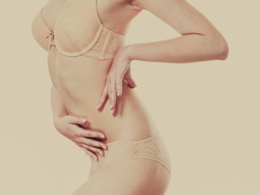 Dantel iç çamaşırı giyen güzel ince sağlıklı kadın. Çekici Bayan ince seksi vücut bej iç çamaşırında gösterilen. Stüdyo çekim görüntü tonda