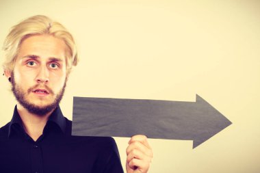 Planlama, yön, seçimler kavramı. Şu terryfied seyir siyah ok işaret tutan adam. Açık renkli üzerinde kapalı atış