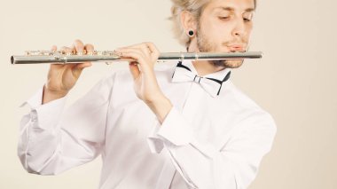 Flüt müziği profesyonel erkek flütçü müzisyen en iyi oyuncusu. Enstrüman genç zarif şık adamla