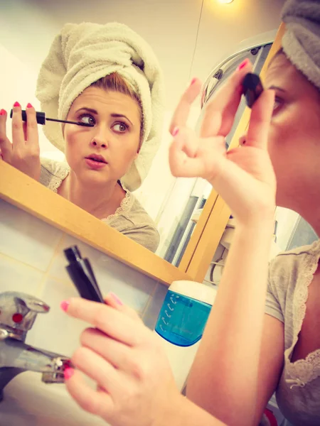 顔とコンセプトを作る まつげのマスカラーを適用する頭にタオルを着て浴室で女性 — ストック写真
