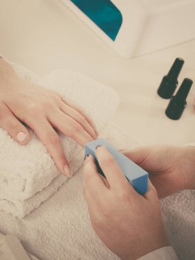 Havlu üzerindeki kadın eli, güzellik uzmanının tırnakları. Güzellik sağlık spa tedavisi, manikür konsepti.