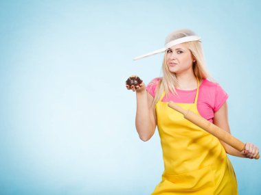 Lezzetli tatlılar tatlılar ev concept, pişirme. Lezzetli çikolatalı kek, oklava kafasına şapka olarak önlük ve kevgir üzerinde tutan kadın.