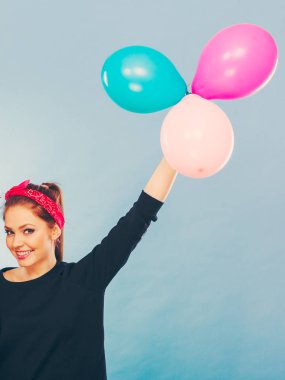 Sevinç eğlence ve özgürlük kavramı. Topları uçan renkli lateks balonlar ile sarışın gülümseyen kadın. Retro moda tarz kız portre.