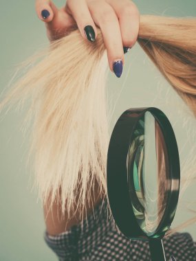 Saç bakım ve saç şekillendirme, kavram ağartma kötü etkiler. Sarışın kadın bozuk, bölünmüş saçları seyir büyüteç ile sona erer..