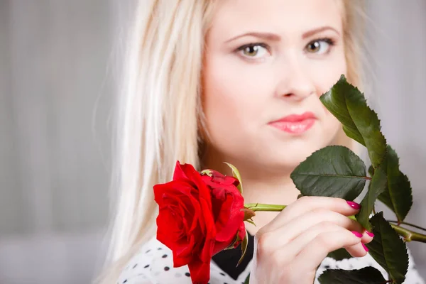 ロマンス バレンタインの日ギフトのコンセプトです メランコリックなの顔に近いバラの赤を保持している美しい金髪の若い女性 — ストック写真