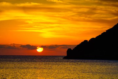 Yunanistan 'da deniz yüzeyinde gün doğumu veya gün batımı manzarası