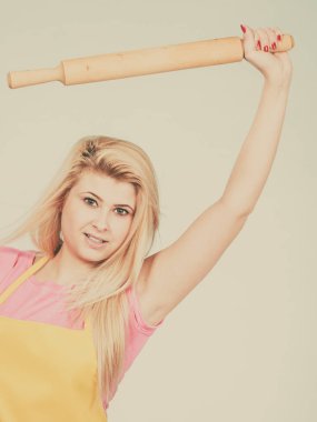 Pişirme, yemek yemek ve gıda kavramı. Oklava tutan sarı önlük giyen kadın hakkında bir şeyler pişirmek için