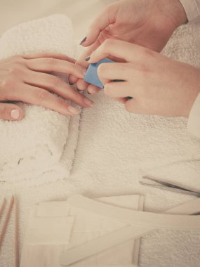 Havlu üzerindeki kadın eli, güzellik uzmanının tırnakları. Güzellik sağlık spa tedavisi, manikür konsepti.