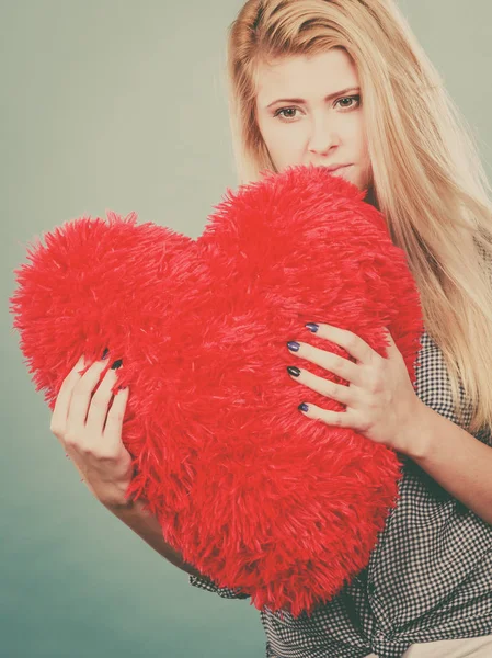 Break up, divorce, bad relationship concept. Sad, depressed woman holding big red fluffy pillow in heart shape, she needs love.
