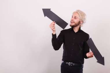 Planlama, yön, seçimler kavramı. Sol ve sağ yön karşısında siyah ok işaret tutan adam. Açık renkli üzerinde kapalı atış