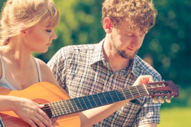 Macera, turizm, yaz tatilinin tadını çıkarmak. Genç bir çift kampta gitar çalarken eğleniyor.