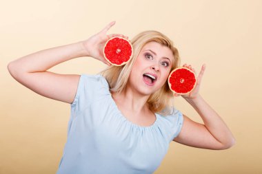 Sağlıklı beslenme, gıda vitamin tam yenileniyor. Mutlu bir kadın tutarak tatlı lezzetli narenciye meyve, kırmızı greyfurt eğleniyor.