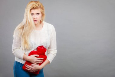 Ağrılı dönemler ve menstrüel kramp sorunları kavramı. Mide krampları sıcak su şişesi tutan çok iyi duygu duygu kadın.