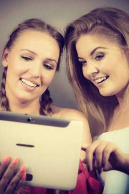 Eğleniyor koltukta oturan kadınlar akıllı dijital pc tablet modern cihaz kullanarak internette sörf