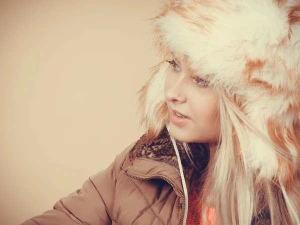 Accessories and clothes for cold days, fashion concept. Blonde woman in winter warm furry hat in russian style