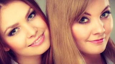 Aile ve ilişkileri. Aşk ve sevgi kavramı. Birlikte oynayan iki güzel çekici kadın. Büyüleyici oynak kız gülümseyerek eğlenceler.