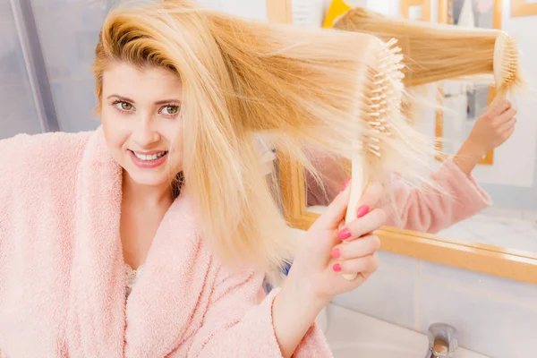 Kobieta Sobie Szlafrok Szczotkowanie Jej Długie Blond Włosy Rano Rutynowych — Zdjęcie stockowe