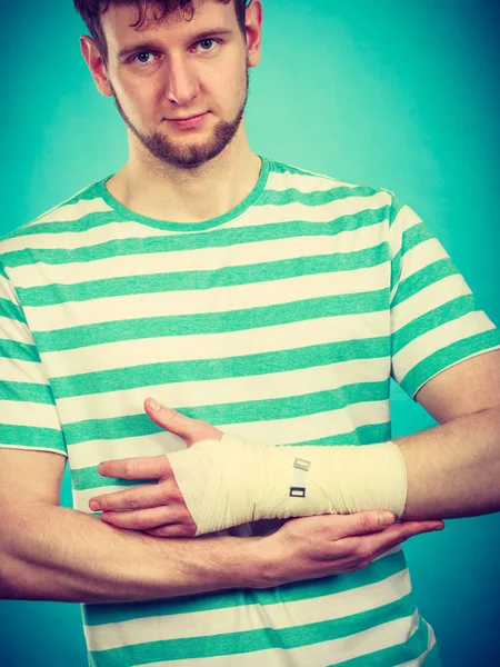 骨折と脱臼のコンセプトです 包帯の手を持つ男 若い男の痛いヤシ アームの有用な薬 — ストック写真