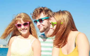 Dostluk mutluluk yaz tatil kavramı. Arkadaşlar çocuk iki kız açık gökyüzü karşı neşe neşeli ruh eğleniyor renkli güneş gözlüğü grubu.