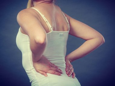 Uzun çalışma saatleri ve sağlık. Genç kadın sırt ağrısı ile. Gri sırt ağrısı muzdarip kadın