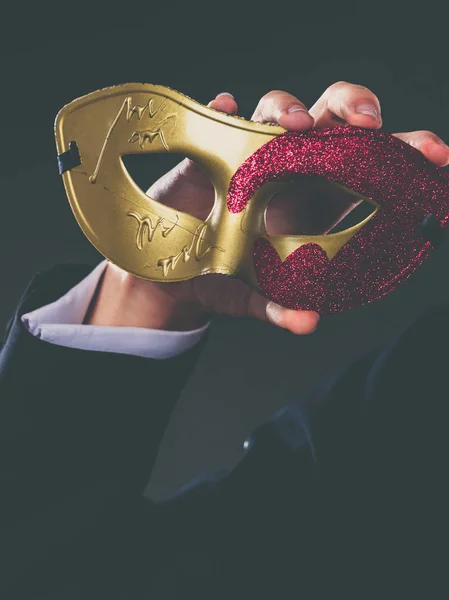 とお祝いの概念 暗い男性手赤ゴールデン カーニバル マスクのクローズ アップ — ストック写真