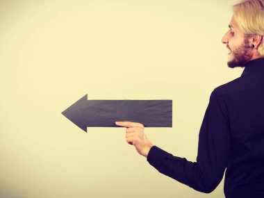 Planlama, yön, seçimler kavramı. Siyah ok sol işaret tutan adam. Açık renkli üzerinde kapalı atış