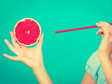 Sağlıklı beslenme, vitamin dolu ferahlatıcı yiyecekler. Meyve suyu içen bir kadın, kırmızı greyfurt.