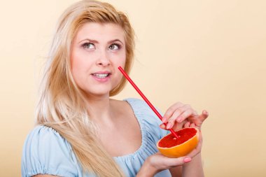 Sağlıklı beslenme, vitamin dolu ferahlatıcı yiyecekler. Sulu meyve suyu içen kadın, kırmızı greyfurt.