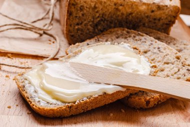 Natürmort taze kepekli ekmek tereyağı ve bal rustik ahşap masa arka plan ile