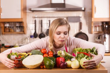 Masada bir sürü sağlıklı sebzesi olan komik, neşeli genç bir kadın. Domates, soğan, marul, biber. Vejetaryen yaşam tarzı konsepti.