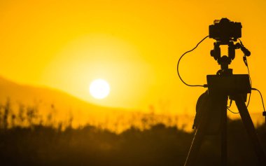 Çayır alanın üzerine, Yunanistan resmi film sunrise video alarak tripod üzerinde profesyonel fotoğraf makinesi