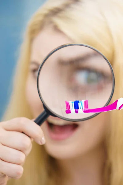 美しい完璧主義者若い女性 Manifying ルーペ ガラスを通して彼女の歯ブラシをチェックします 不稔性の概念 — ストック写真