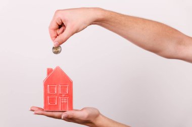 Ev tasarruf ve finans, ekonomi kavramı. Kumbara house, stüdyo ışık arka plan üzerinde atış şeklinde para madeni para koyarak adam