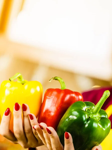 Woman hand holding bell pepper delicious healthy dieting vegetable presenting diet food in three colors