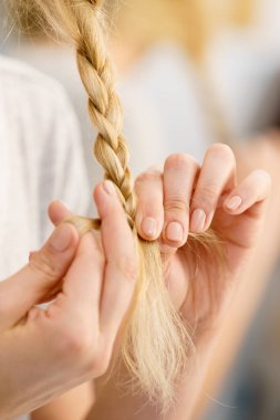 Genç, güzel sarışın kadın saç modelini yapıyor, örgü örüyor. Güzel bayan hazırlanıyor.