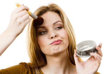 Profesyonel pudra fırçası tutan zarif, genç bayan makyajına son bir dokunuş ekliyor.