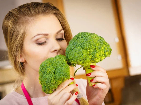 stock image Happy young woman holding raw green vegetable broccoli. Natural organic healthy food concept.