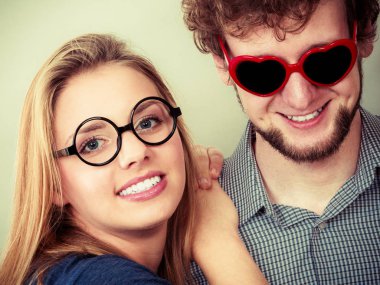 Kalp şeklinde gözlük ve kadın mutlu genç adam. Gülümseyen arkadaş çift Studio.