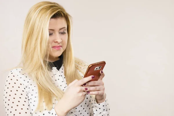 Mujer Con Expresión Facial Neutra Usando Smartphone Comprobando Redes Sociales — Foto de Stock