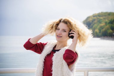 Dışarıda müzik dinleyen neşeli bir kadın. Kulaklık takan genç bir bayan yürüyüş yaparken eğleniyor..