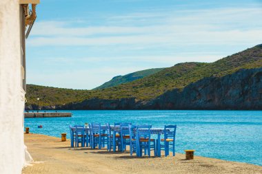 Deniz kenarındaki mavi masa ve sandalyeler deniz kıyısında Yunanistan 'da açık bir kafe restoranı açıyor. Yaz tatili.