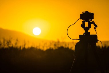Çayır alanın üzerine, Yunanistan resmi film sunrise video alarak tripod üzerinde profesyonel fotoğraf makinesi
