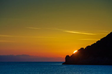 Yunanistan 'da deniz yüzeyinde gün doğumu veya gün batımı manzarası