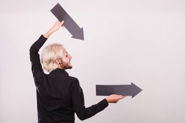 Planlama, yön, seçimler kavramı. Şu iki siyah oklar tutan adam. Açık renkli üzerinde kapalı atış