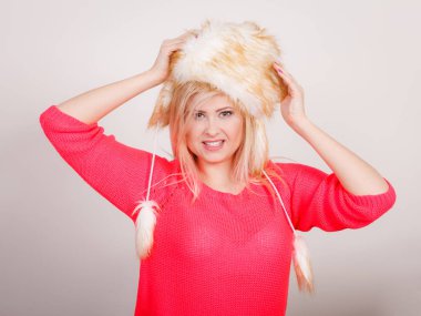 Soğuk günlerde fikirler, moda ve giyim konsept için kıyafet. Tüylü kış şapka giyen çekici gülümseyen sarışın kadın