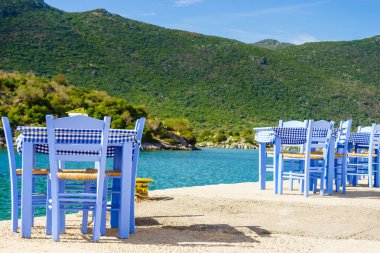 Deniz kenarındaki mavi masa ve sandalyeler deniz kıyısında Yunanistan 'da açık bir kafe restoranı açıyor. Yaz tatili.