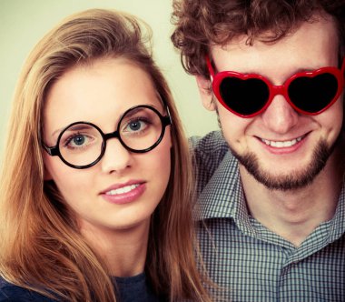 Kalp şeklinde gözlük ve kadın mutlu genç adam. Gülümseyen arkadaş çift Studio.